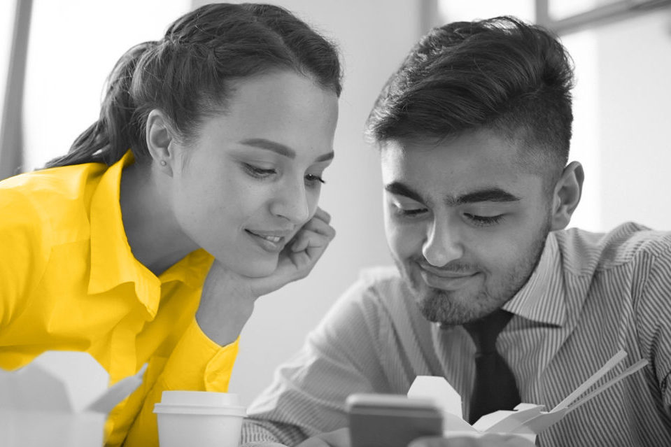 two people looking down at a phone screen